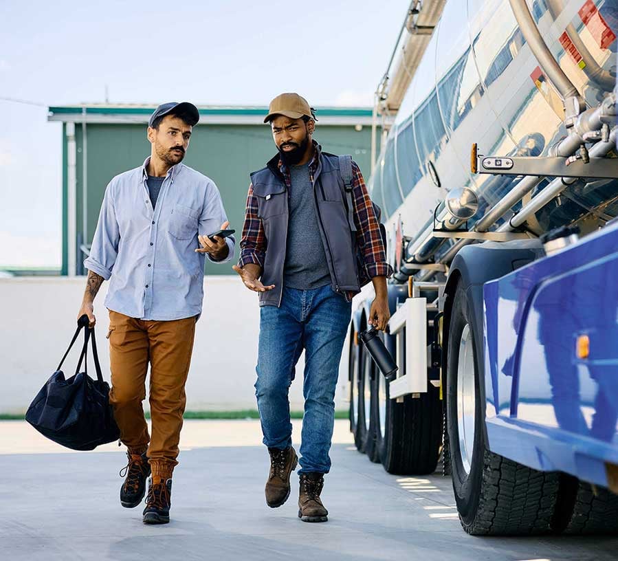 Two businessmen walk near truck purchased with a Red Canoe Business Vehicle Loan