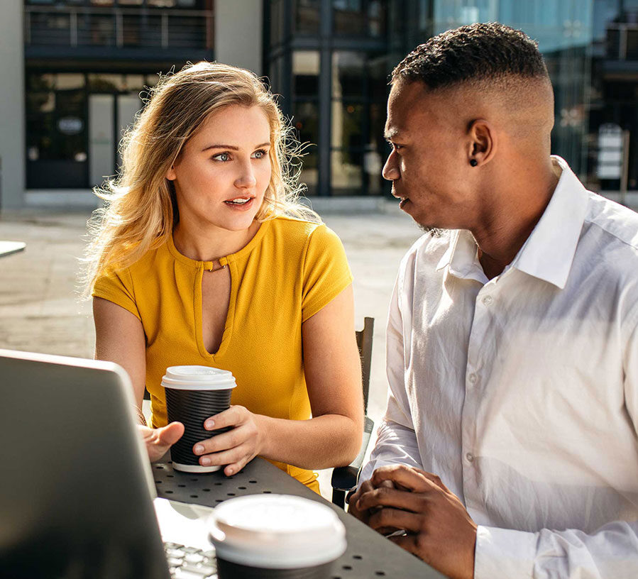 A man and woman sit at a computer and discuss Account Security at Red Canoe Credit Union