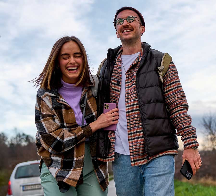 Young couple with a Red Canoe Round Up Savings account walking in the fall