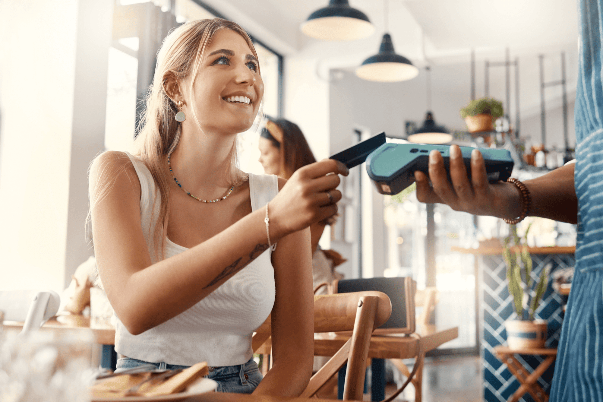 woman using red canoe credit card at restaurant