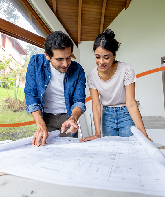 Man and women looking at home construction blueprints