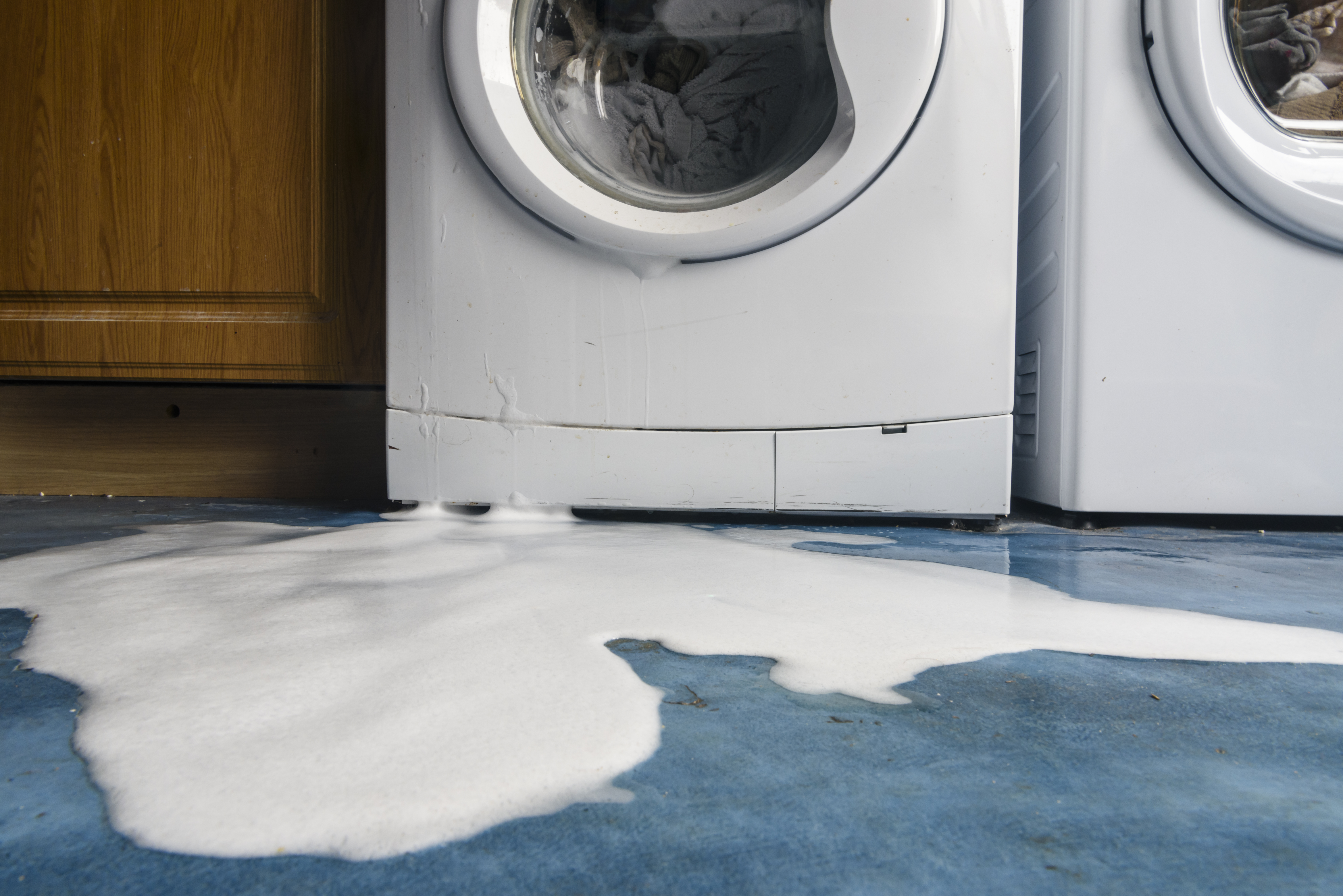 broken washing machine leaking on the floor