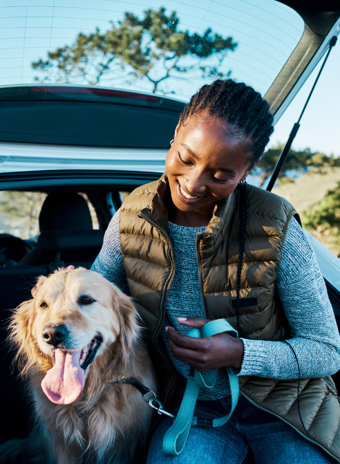woman and dog in back of her vehicle